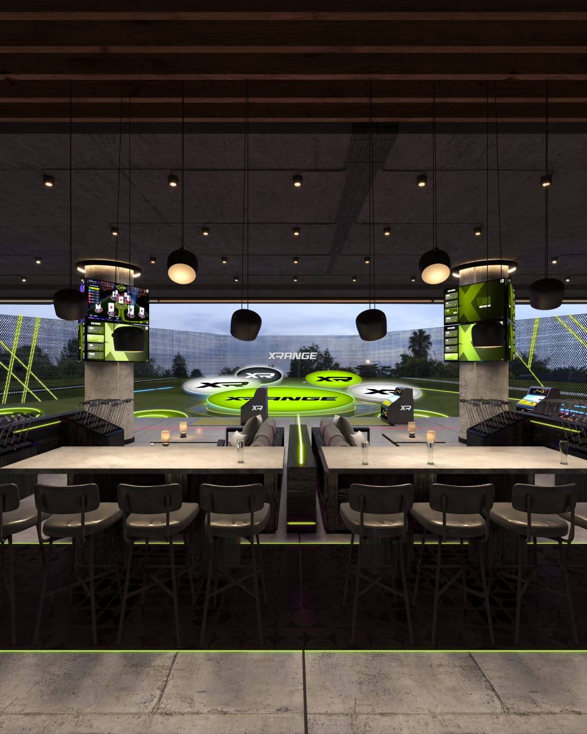 Long communal tables and high-backed seating set behind two hitting bays, with scoring screens mounted on the columns and the target greens beyond.