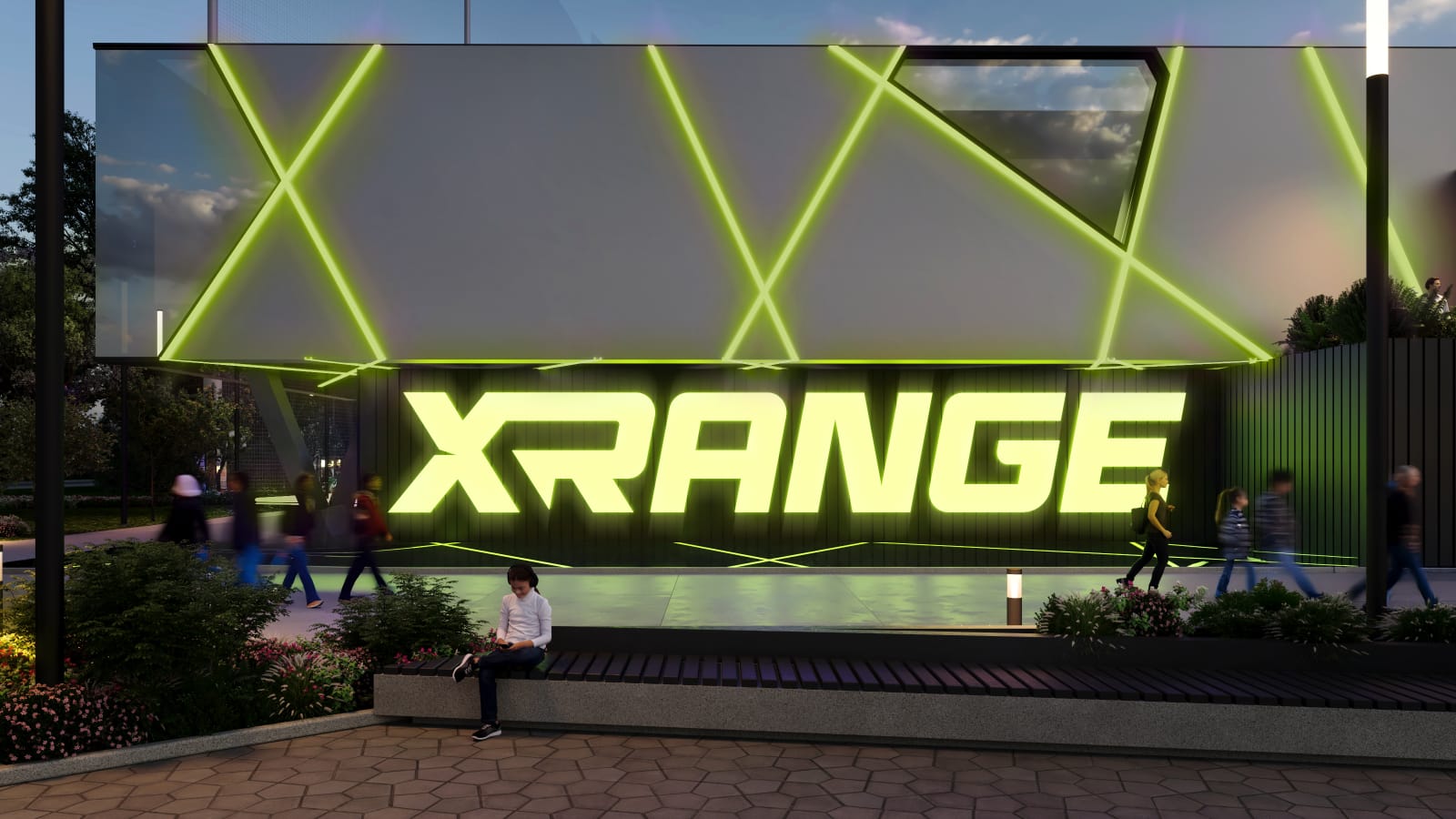 Pedestrians passing the illuminated XRANGE wordmark on the dark facade, with a seating bench and planting in the foreground.