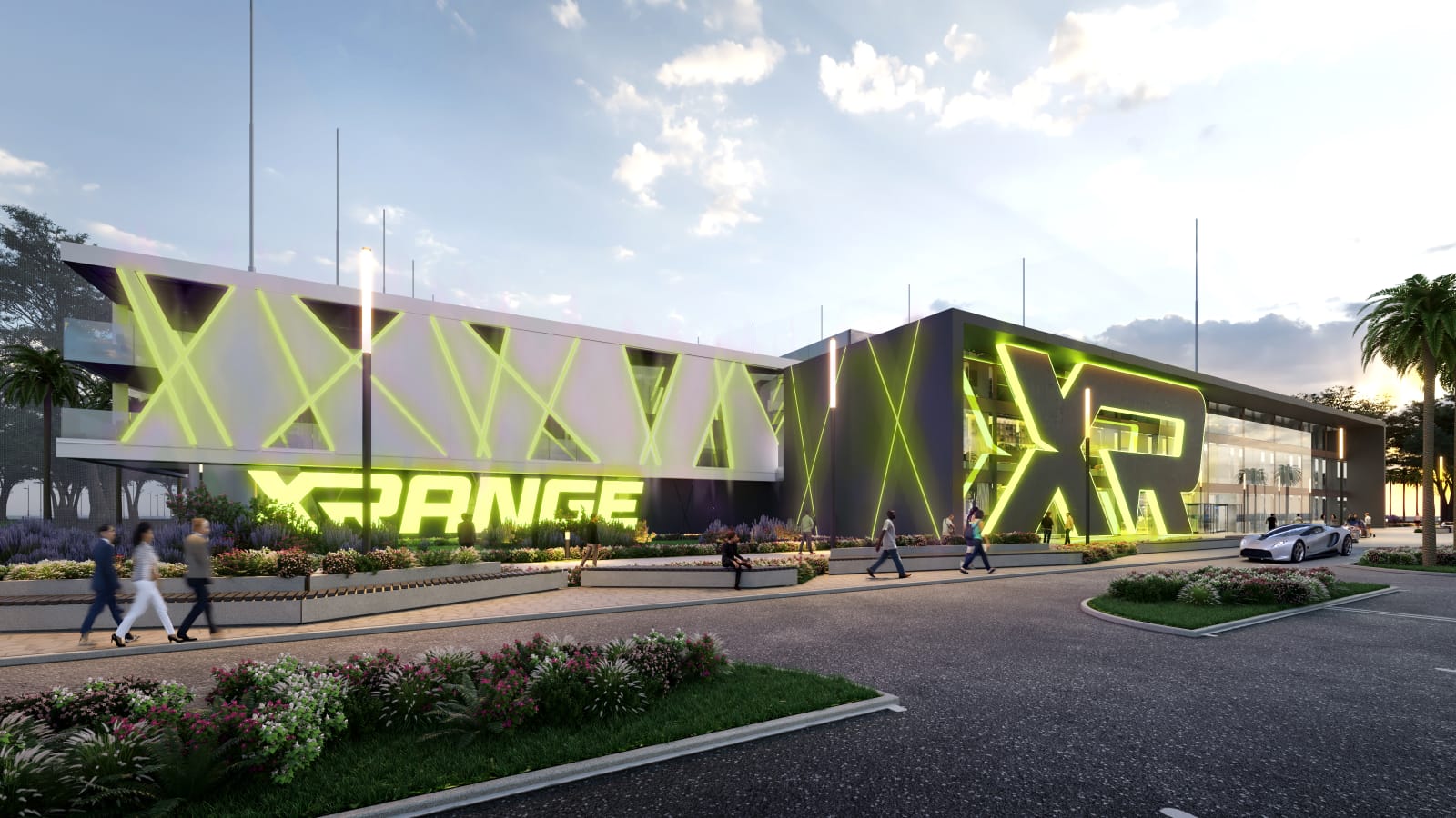 Wide street view of the XRANGE clubhouse at dusk, showing the illuminated X-frame panels along the upper facade and the XRANGE wordmark at ground level.